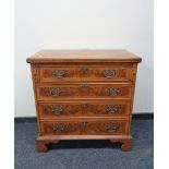 A Chapman's Siesta Georgian style burr walnut veneered four drawer chest with metal drop handles