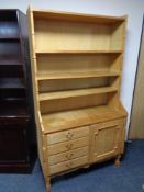 A set of continental blonde oak open bookshelves, fitted four drawers and cupboard beneath.