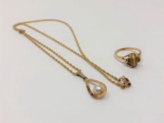 A gold pearl pendant on chain and a gold tiger's eye set ring (2)