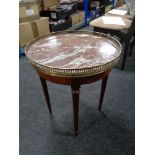 A circular mahogany marble topped occasional table with brass gallery.
