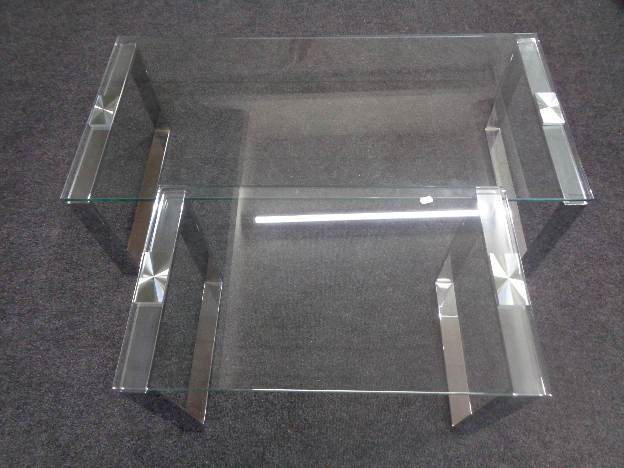 Two contemporary glass topped coffee tables on metal legs.