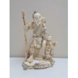 A Japanese carved bone okimono figure group, Oriental gentleman with child,