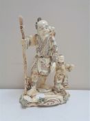 A Japanese carved bone okimono figure group, Oriental gentleman with child,