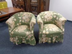 A pair of early 20th century tub chairs upholstered in a green floral fabric on Queen Anne legs.