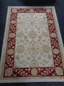 A machine made woolen rug of floral design on cream ground