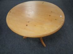 A circular pine pedestal dining table