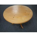 A circular pine pedestal dining table