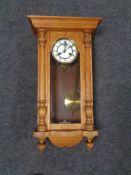 A 20th century oak wall clock with brass and enamel dial.