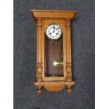 A 20th century oak wall clock with brass and enamel dial.