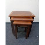 A nest of three inlaid yew wood tables together with an oval yew wood pedestal wine table.