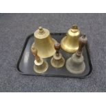 A tray containing two brass ship's style bells together with three further brass wooden handled