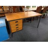 A mid 20th century teak single pedestal desk on metal legs.