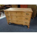 A blonde oak serpentine fronted three drawer chest. Height 69 cm, width 97 cm, depth 47 cm.