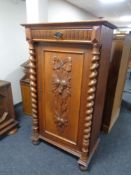 An early 20th century oak cupboard with carved panel door,