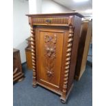 An early 20th century oak cupboard with carved panel door,