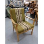 A blond oak framed armchair in green striped fabric