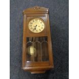 An early 20th century oak cased wall clock with silver dial.