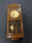 An early 20th century oak cased wall clock with silver dial.