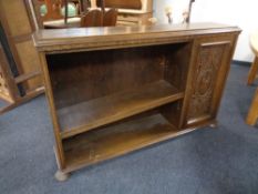 A set of twentieth century oak open bookshelves with carved panel door on bun feet (as found)