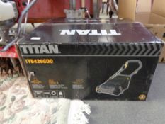 A boxed Titan lawn scarifier together with Titan pole saw attachments and a bundle of garden tools.