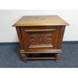 An early 20th century carved oak panel door cabinet on raised legs.