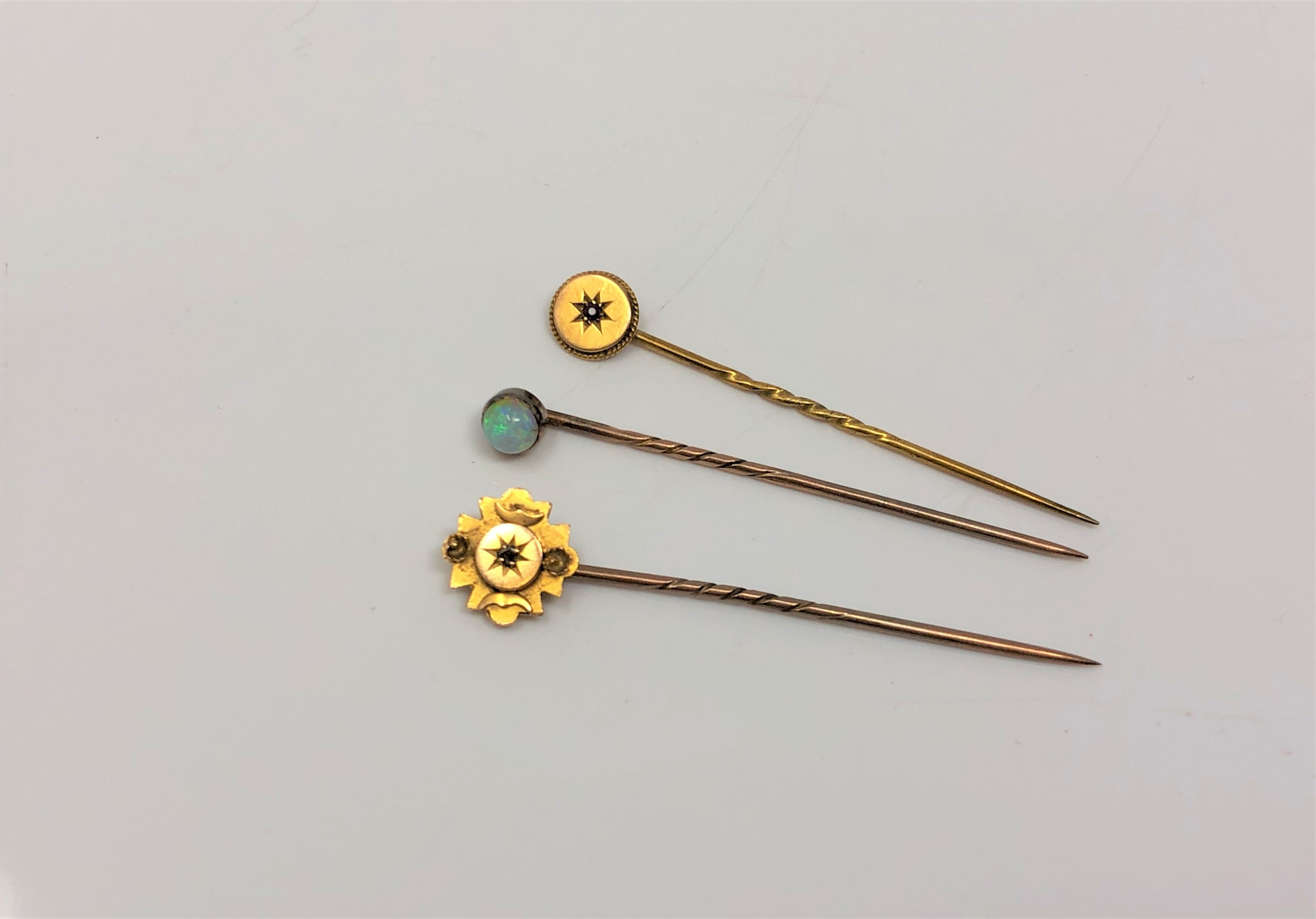 Three gold pins, two marked 15ct and set with diamond and ruby,