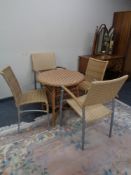 A circular wicker conservatory table together with four rattan chairs on metal legs