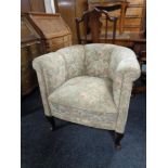 A 20th century tub chair upholstered in a floral fabric on Queen Anne legs.