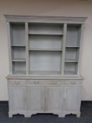 A shabby chic bookcase, fitted cupboards and drawers beneath.