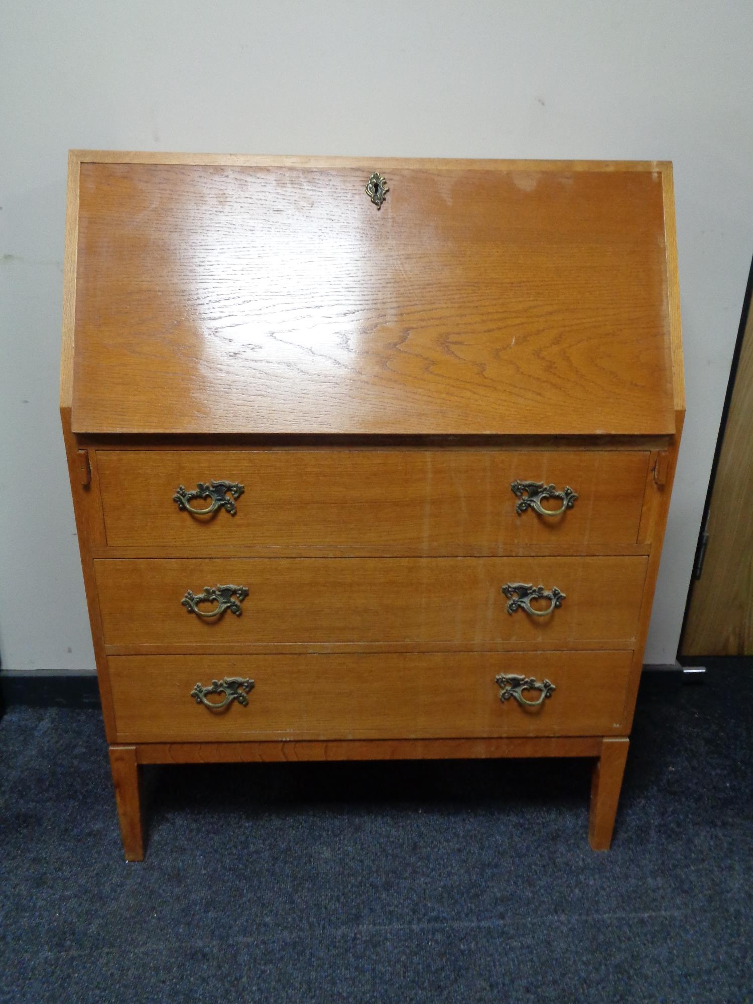 A 20th century oak writing bureau, fitted three drawers.