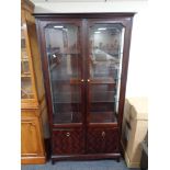 A Stag Minstrel double door glazed display cabinet, fitted cupboards beneath.