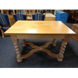 An early 20th century oak dining table on barley twist legs with under stretcher.