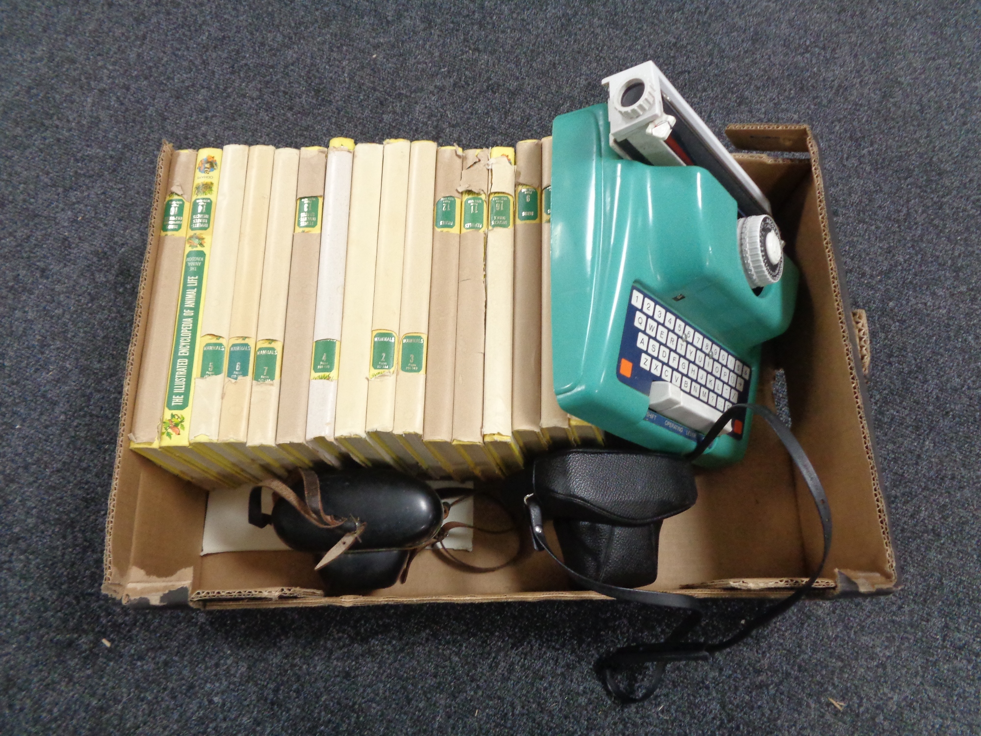 A box containing children's encyclopedias, a toy typewriter together with two vintage cameras.