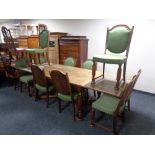 A 20th century oak pull out dining table together with a set of ten matching chairs upholstered in