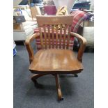 An Edwardian oak swivel desk armchair