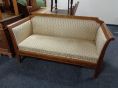 An early twentieth century inlaid mahogany framed settee in Regency stripe fabric