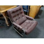 A 20th century Burgundy button leather and tubular metal armchair.
