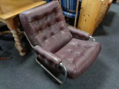 A 20th century Burgundy button leather and tubular metal armchair.