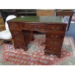 A mahogany twin pedestal desk fitted nine drawers with green tooled leather inset panel