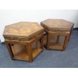 A pair of hexagonal two tier tables with brass handles and mounts.