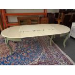 A painted circular continental dining table with three extension leaves