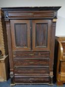 An antique stained pine storage cupboard in the form of a chest.