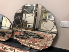 A frameless flower-head mirror,