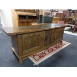 A 20th century continental oak double door low sideboard with carved central panel.