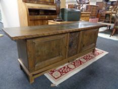 A 20th century continental oak double door low sideboard with carved central panel.