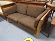 A mid century teak framed two seater settee in brown fabric