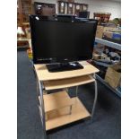 A Logik 26'' LCD TV with remote on computer trolley.