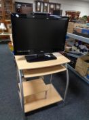 A Logik 26'' LCD TV with remote on computer trolley.