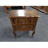 A 20th century carved beech wood two drawer chest.