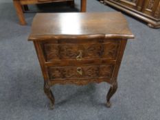 A 20th century carved beech wood two drawer chest.